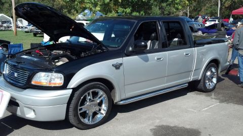 2007 Ford Mustang - A two-tone silver and black Ford F-150 SVT Lightning pickup truck is displayed with its hood open.