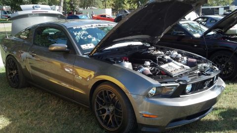 2007 Ford Mustang - A modified Ford Mustang is displayed with its hood up, revealing the engine bay, at an outdoor car show.