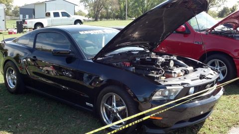 2007 Ford Mustang - A black Ford Mustang, likely a 2010 model, is displayed with its hood open, revealing the engine compartment and drag racing tires.