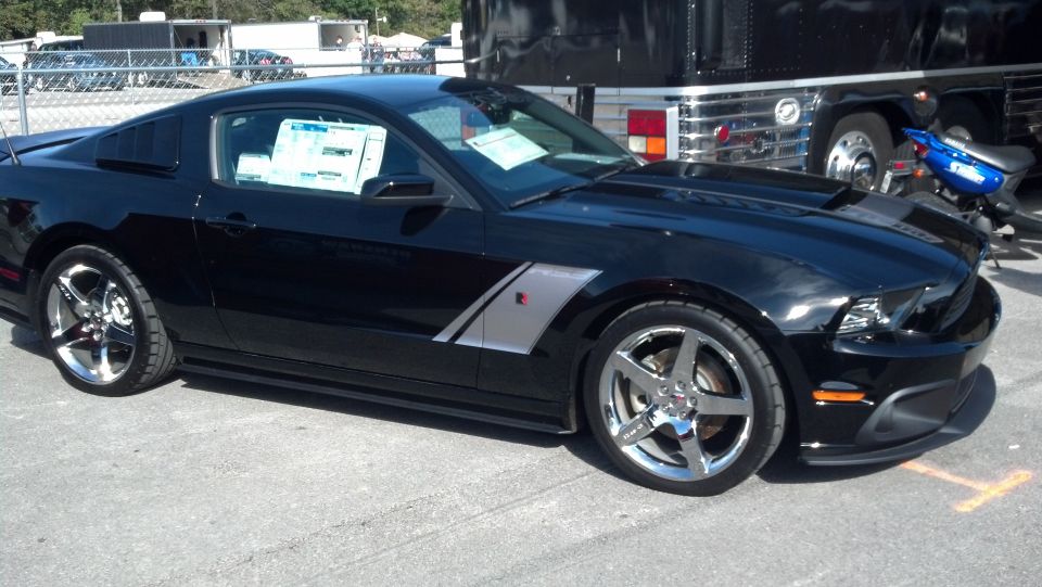 Black 2007 Ford Mustang parked outdoors, side view showing custom wheels and body trim
