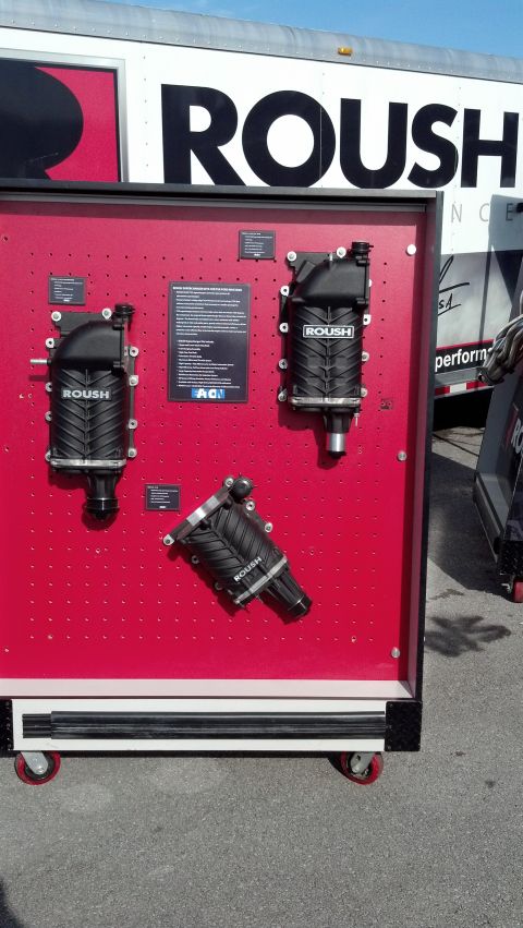 2007 Ford Mustang - Roush superchargers are displayed on a red board, with a Roush branded trailer in the background.