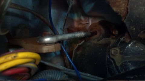 1986 Ford Bronco - Detail of a mechanical linkage, possibly for a clutch system, with visible wiring and mounting hardware.