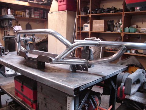 1989 Ford Bronco - Custom tube bumper assembly on a workbench in a workshop setting.
