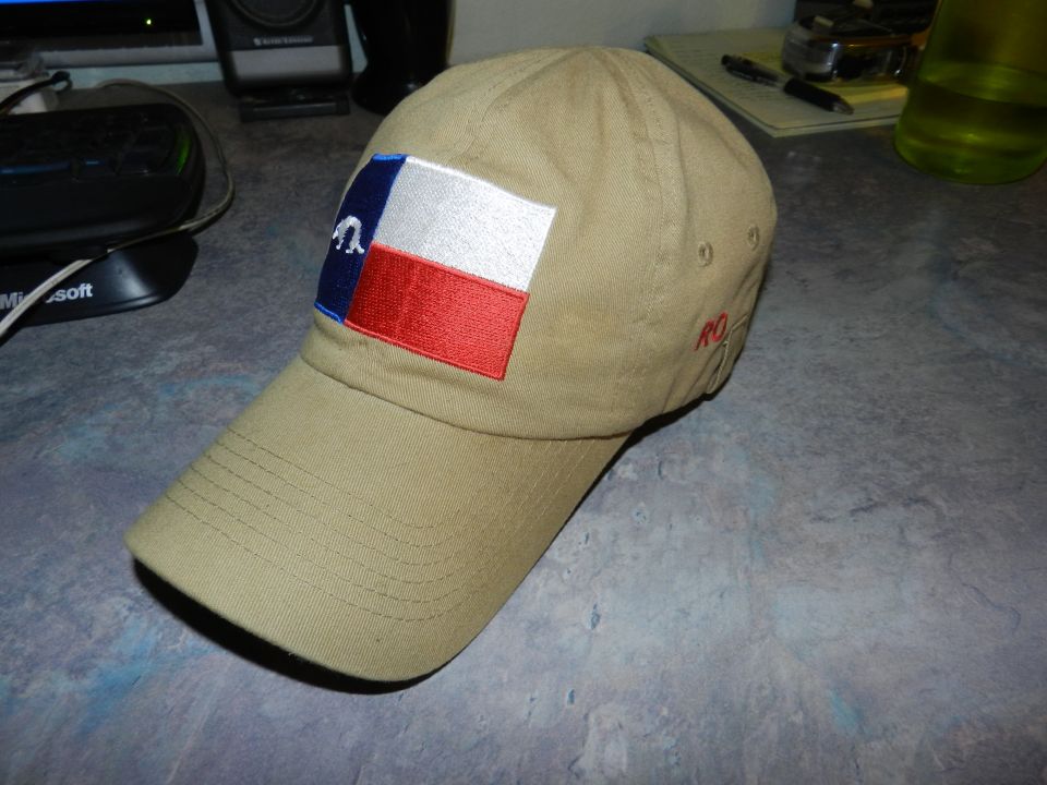 Tan baseball cap with Texas flag patch and red embroidery on the side