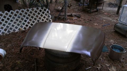 1978 Ford Bronco - A vehicle hood is prepped for painting, with one section covered in white primer.