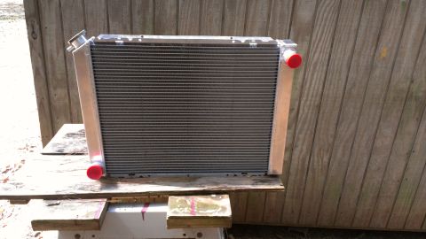 1978 Ford Bronco - A car radiator is shown resting on wooden supports in front of a weathered wooden fence.