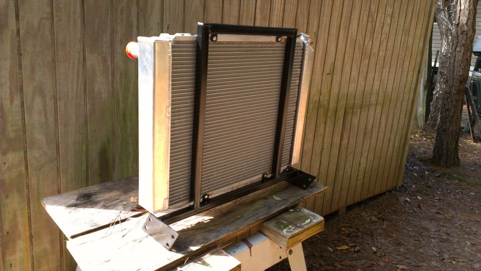 Radiator assembly with black metal frame, mounted on wooden sawhorses