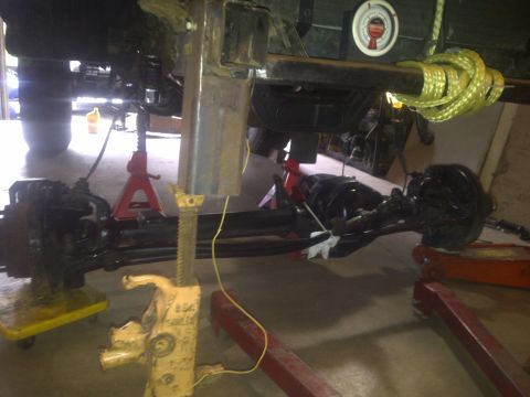 1995 Ford Bronco - Vehicle's undercarriage and suspension components are visible while it is supported by jack stands.