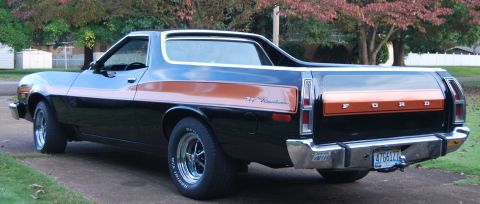 1975 Ford Ranchero - The rear of a black 1975 Ford Ranchero pickup truck with an orange stripe and chrome bumper.