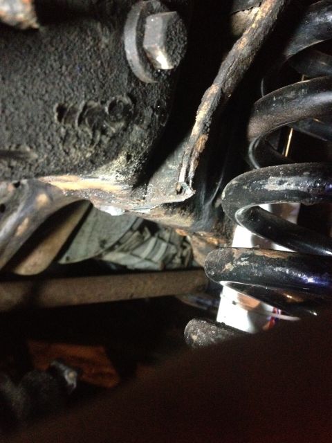 1996 Ford F-150 - Detail of a vehicle's suspension system, showing a coil spring and rusty metal components.