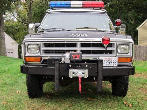 1987 Dodge 1500 - Front view of a black Dodge Ram pickup truck equipped with emergency lights and a winch.