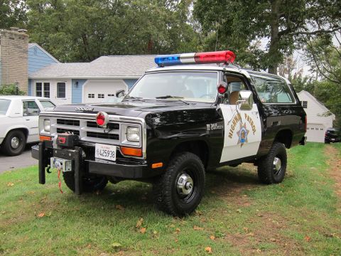 1987 Dodge 1500 - This 1987 Dodge Ramcharger police SUV features a distinctive black and white paint scheme, a light bar, and a front-mounted winch.