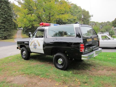 1987 Dodge 1500 - This Dodge Ramcharger is marked as Highway Patrol, with a light bar on top. A second vehicle is parked nearby.