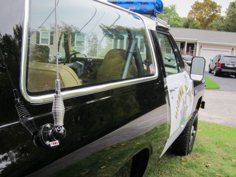 1987 Dodge 1500 - 1987 Dodge 1500 highway patrol vehicle, seen from the side. A second vehicle is visible in the background.