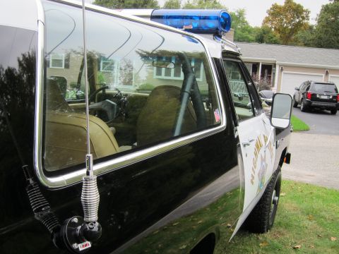 1987 Dodge 1500 - This police vehicle has "HIGHWAY PATROL" written on its side. A second SUV is visible in the background.