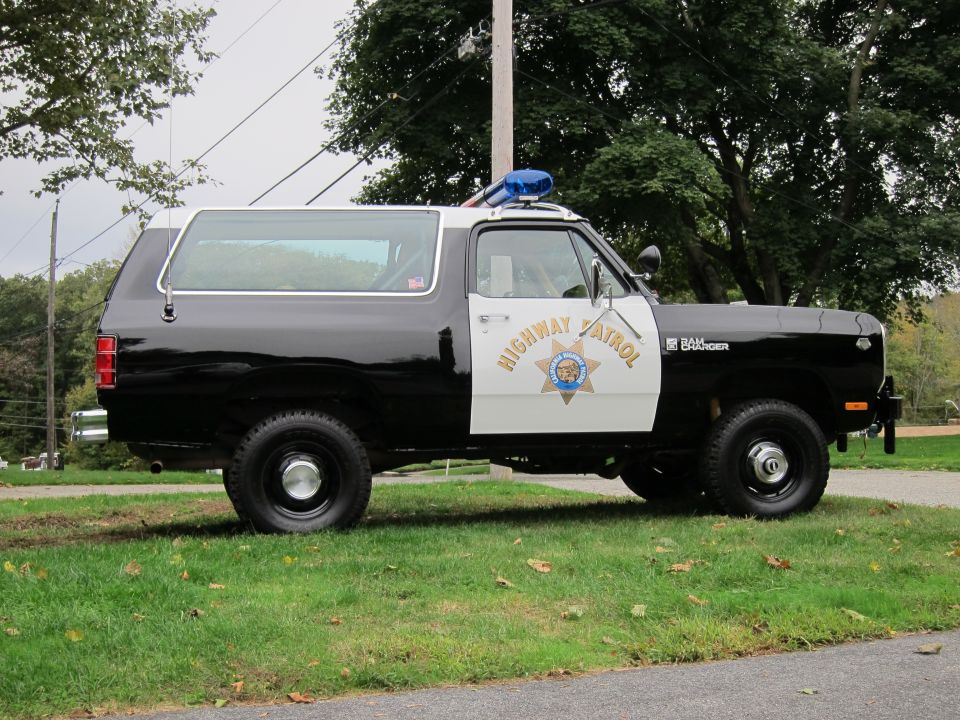 Side view of a black and white 1987 Dodge Ramcharger SUV with "HIGHWAY PATROL" markings