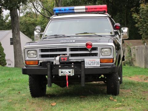 1987 Dodge 1500 - Front view of a black 1987 Dodge 1500 police truck equipped with a light bar and a winch.
