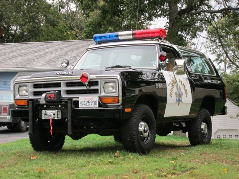 1987 Dodge 1500 - This black and white Dodge Ramcharger is equipped as a police vehicle with a light bar and siren.