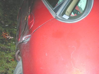 1997 Ford Taurus - Damage is visible on the rear quarter panel of this red car, near the door handle.