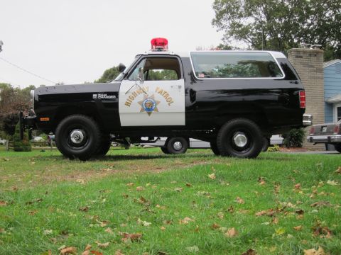 1987 Dodge 1500 - This Dodge Ramcharger, marked as Highway Patrol, is parked on a grassy lawn next to a house.