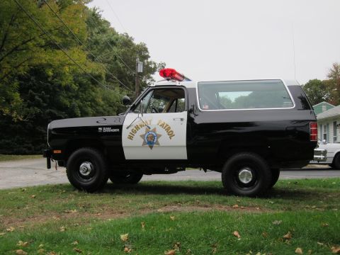 1987 Dodge 1500 - This 1987 Dodge Ramcharger, marked as Highway Patrol, presents a classic side profile with its distinctive two-tone paint scheme and emerge…