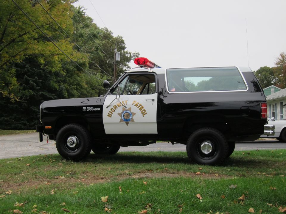 Side view of black and white 1987 Dodge Ramcharger Highway Patrol SUV with light bar