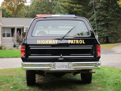 1987 Dodge 1500 - This Dodge Ramcharger, marked as a highway patrol vehicle, is parked on a grassy area in front of a house.