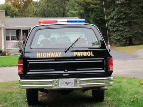 1987 Dodge 1500 - Rear view of a black SUV with a light bar and 'HIGHWAY PATROL' text.