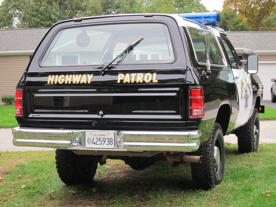 Black Dodge Ramcharger with "HIGHWAY PATROL" text, rear view