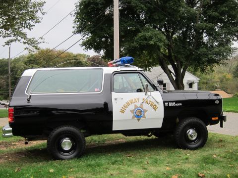 1987 Dodge 1500 - A side view of a black and white Dodge Ramcharger police SUV with "Highway Patrol" markings and a light bar on the roof.