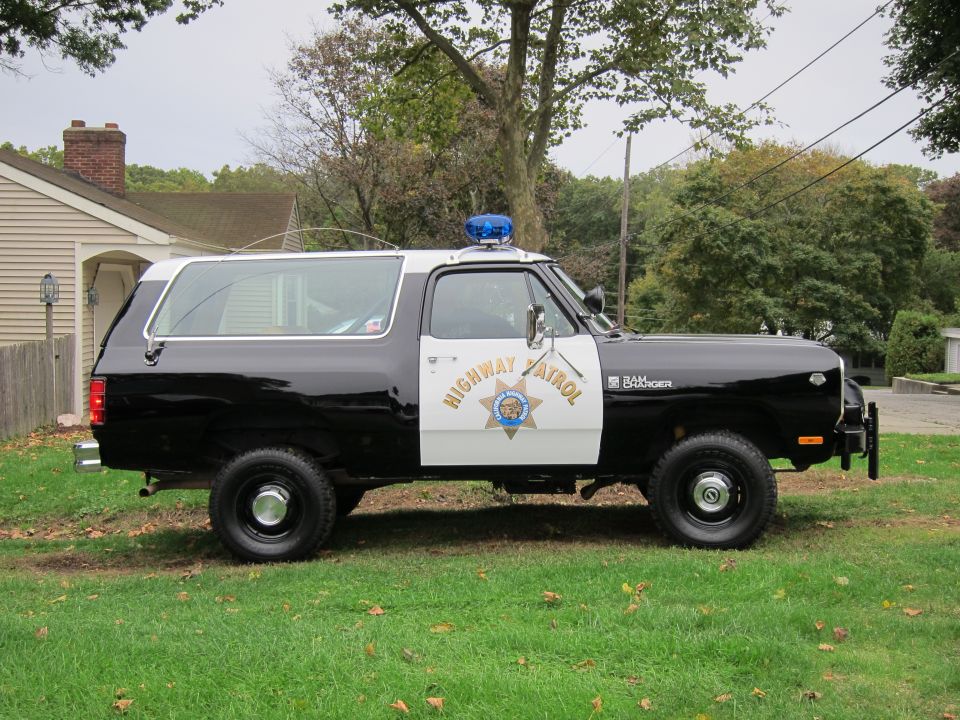 Side view of a 1987 Dodge Ramcharger police vehicle with "Highway Patrol" text and a blue light bar