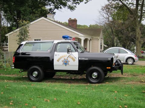1987 Dodge 1500 - Side view of a 1987 Dodge Ramcharger police vehicle, also known as a Ramcharger, parked on grass.