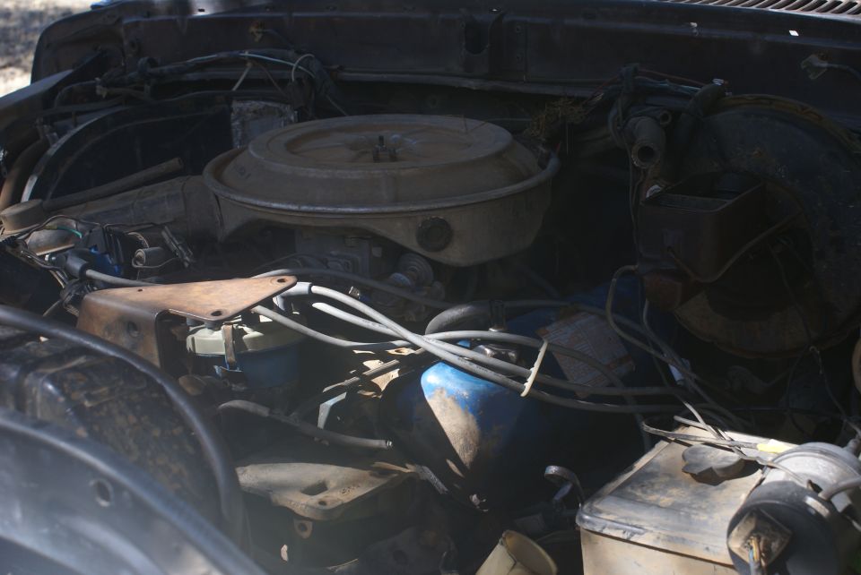 Engine bay with air cleaner, carburetor, and wiring visible
