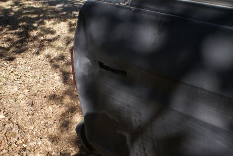 1978 Ford Bronco - Damage to the rear quarter panel of a vehicle, with visible rust and a dent.