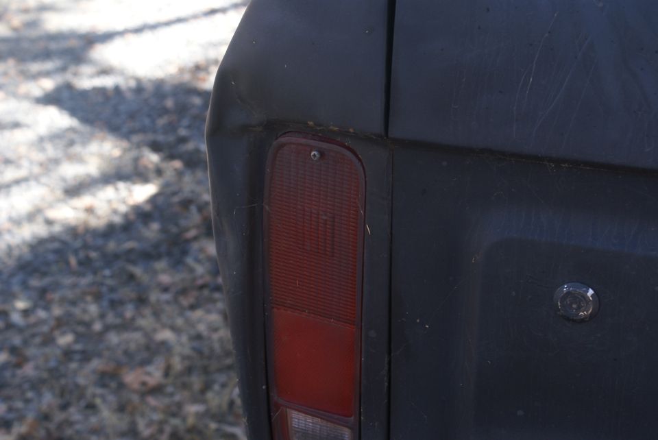 1978 Ford Bronco rear quarter panel with taillight visible. Dark paint shows some scratches