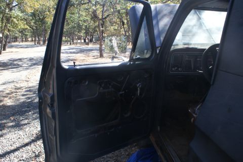 1978 Ford Bronco - Interior view of a 1978 Ford Bronco with the driver's side door open and interior panels removed.