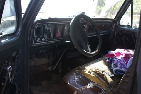 1978 Ford Bronco - Interior view of a 1978 Ford Bronco, showing the dashboard and damaged seats.
