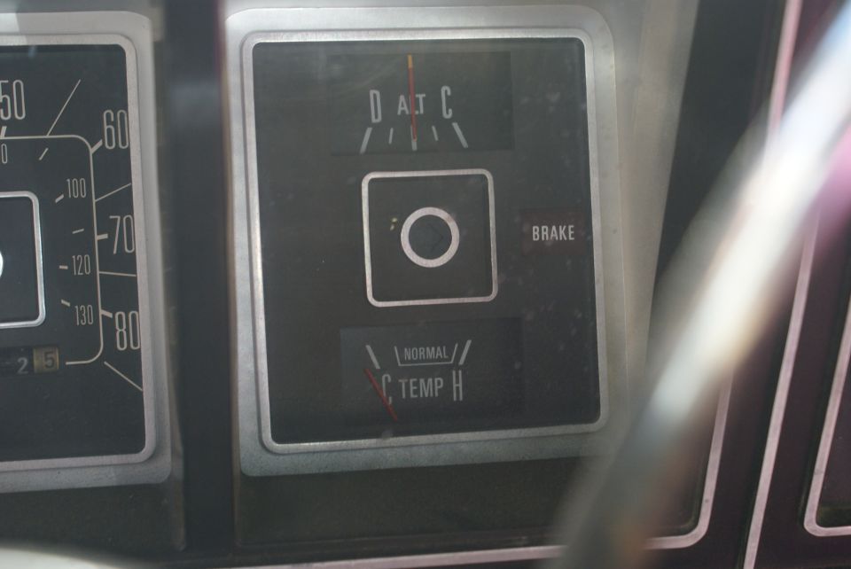 Close-up of dashboard gauges showing temperature and brake warning lights