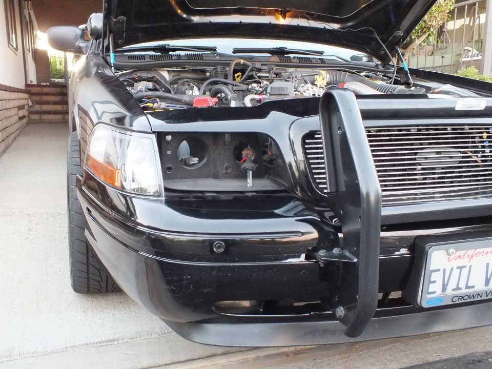 Black Crown Victoria front corner with headlight removed and EVIL plate visible
