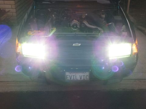 2003 Ford Crown Victoria - Lens-flare close shot of the EVIL VIC Crown Victoria with billet grille and twin glowing HID headlights