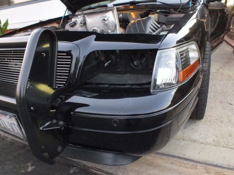 2003 Ford Crown Victoria - Bare headlight cavity on the black Crown Victoria with push bar attached and amber marker still in place