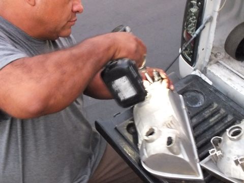 2003 Ford Crown Victoria - Close shot of hands working a black power tool over an aluminum part on the tailgate
