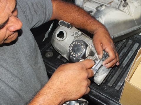 2003 Ford Crown Victoria - Man positioning a numbered black dial against a machined aluminum part on the pickup bedliner
