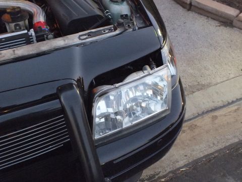 2003 Ford Crown Victoria - Newly fitted crystal headlight on the black Crown Victoria, push bar and billet grille framing the corner