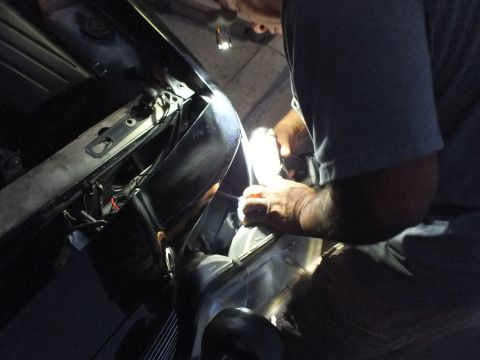 2003 Ford Crown Victoria - Close work on the radiator and front core of a dark sedan lit by a worklight in the dark