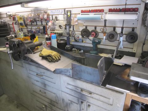 2008 Jeep Wrangler - A workbench is set up with tools and metal components, suggesting a fabrication or repair environment.