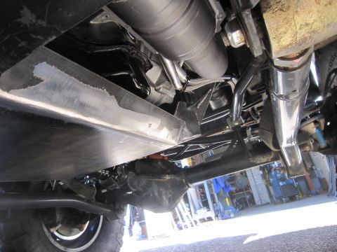 2008 Jeep Wrangler - The undercarriage of a vehicle is visible, skid plates and exhaust pipes.
