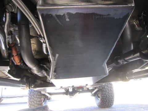 2008 Jeep Wrangler - Custom skid plate and exhaust system shown from underneath a vehicle.