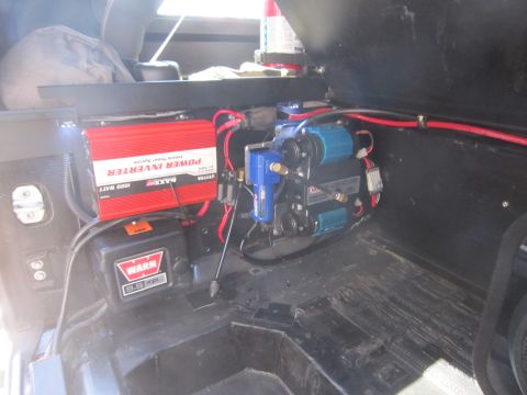 2008 Jeep Wrangler - The interior of a vehicle shows a power inverter, air compressor, and winch controller mounted to the floor.