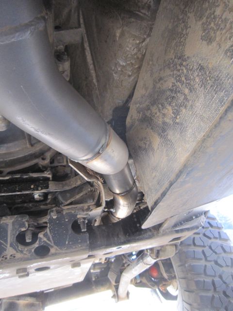 2008 Jeep Wrangler - Custom exhaust system components are visible underneath the vehicle, including a large muffler and bent piping.